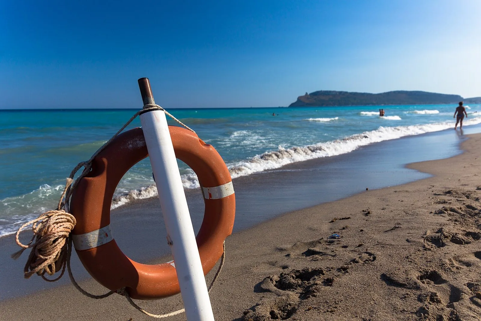 Una spiaggia sarda con il mare mosso e le onde che arrivano a riva